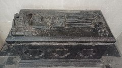 Église Saint-Martin - English: High-angle general view showing the tomb slab and the side of the tomb chest of François de Luxembourg (died 1472). The upper blue stone slab features a recumbent effigy of a child sculpted in high relief, surrounded by a Gothic inscription running along the border. The child's face and hands, originally inset in ivory, have since been lost, leaving the surface of the stone heavily pitted where they were once fixed. The side of the tomb chest is decorated with three blank heraldic shields set within quatrefoil frames. Work dating from the second half of the 15th century, preserved in the choir of Saint-Martin Church in Roubaix (Nord, France). Français : Vue générale plongeante montrant la dalle funéraire et la face latérale de la cuve du tombeau de François de Luxembourg (mort en 1472). La dalle supérieure en pierre bleue comporte un gisant d'enfant sculpté en haut-relief, entouré d'une inscription gothique courant sur la bordure. Le visage et les mains de l'enfant, initialement rapportés en ivoire, ont aujourd'hui disparu, laissant la surface de la pierre fortement piquée à l'endroit de leur fixation. La face latérale de la cuve est ornée de trois écussons sans armoiries, insérés dans des motifs quadrilobés. Œuvre de la seconde moitié du XVe siècle, conservée dans le chœur de l'église Saint-Martin à Roubaix (Nord, France). Nederlands: Algemene opname van bovenaf van de grafplaat en de zijkant van de tombe van François de Luxembourg (overleden in 1472). De bovenste plaat van blauwe hardsteen toont een liggend grafbeeld (gisant) van een kind, in hoogreliëf gebeeldhouwd en omringd door een gotisch opschrift dat langs de rand loopt. Het gezicht en de handen van het kind, oorspronkelijk ingelegd met ivoor, zijn intussen verdwenen, waardoor het steenoppervlak op die plaats sterk beschadigd is. De zijkant van de tombe is versierd met drie wapenschilden zonder heraldische voorstelling, geplaatst binnen vierlobbige omlijstingen. Werk uit de tweede helft van de 15e eeuw, bewaard in het koor van de Sint-Maartenskerk in Roubaix (Nord, Frankrijk).